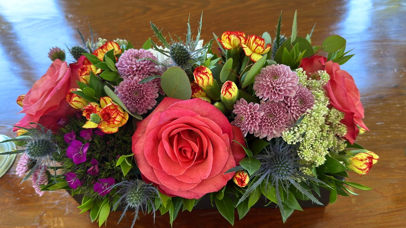 Jewel-toned floral centerpiece with roses and thistle
